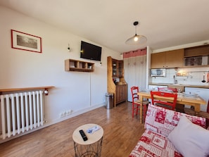 A compact living space with a kitchen, dining area, and a sofa.