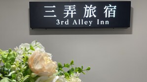 A sign for the 3rd Alley Inn with a floral arrangement in front. - 3rd Alley Inn (Kaohsiung)