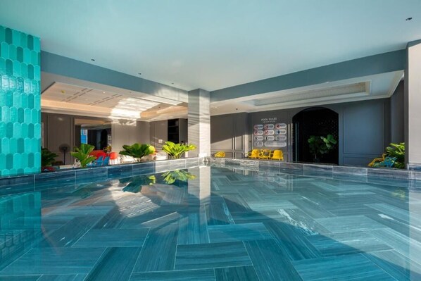 A modern indoor pool area with a clear water surface, surrounded by a tiled floor and walls, and featuring a 'Pool Rules' sign. - Kim Minh Boutique (Ho Chi Minh City)