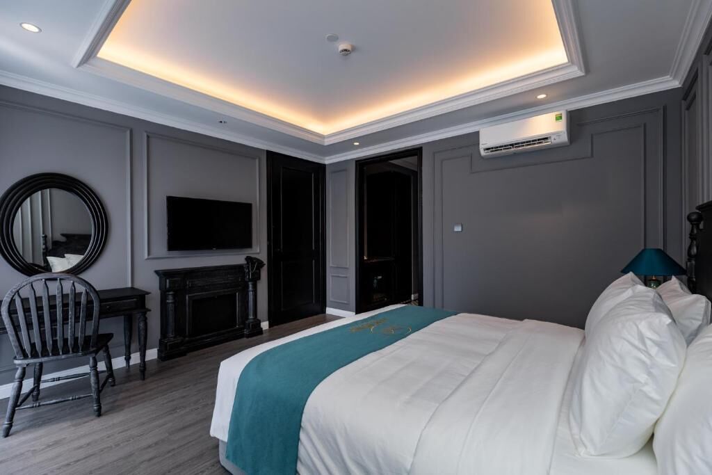 Une chambre d’hôtel avec un grand lit, une télévision, une cheminée et un luminaire au plafond.