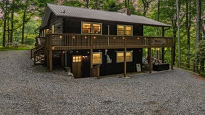 Une cabane dotée d’un balcon, d’une terrasse et d’une allée gravillonnée.