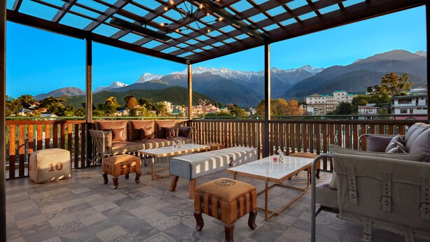 A terrace with outdoor seating, a pergola, and a view of mountains. - Fortune Park Palampur - Member ITC Hotels' Group (Palampur)
