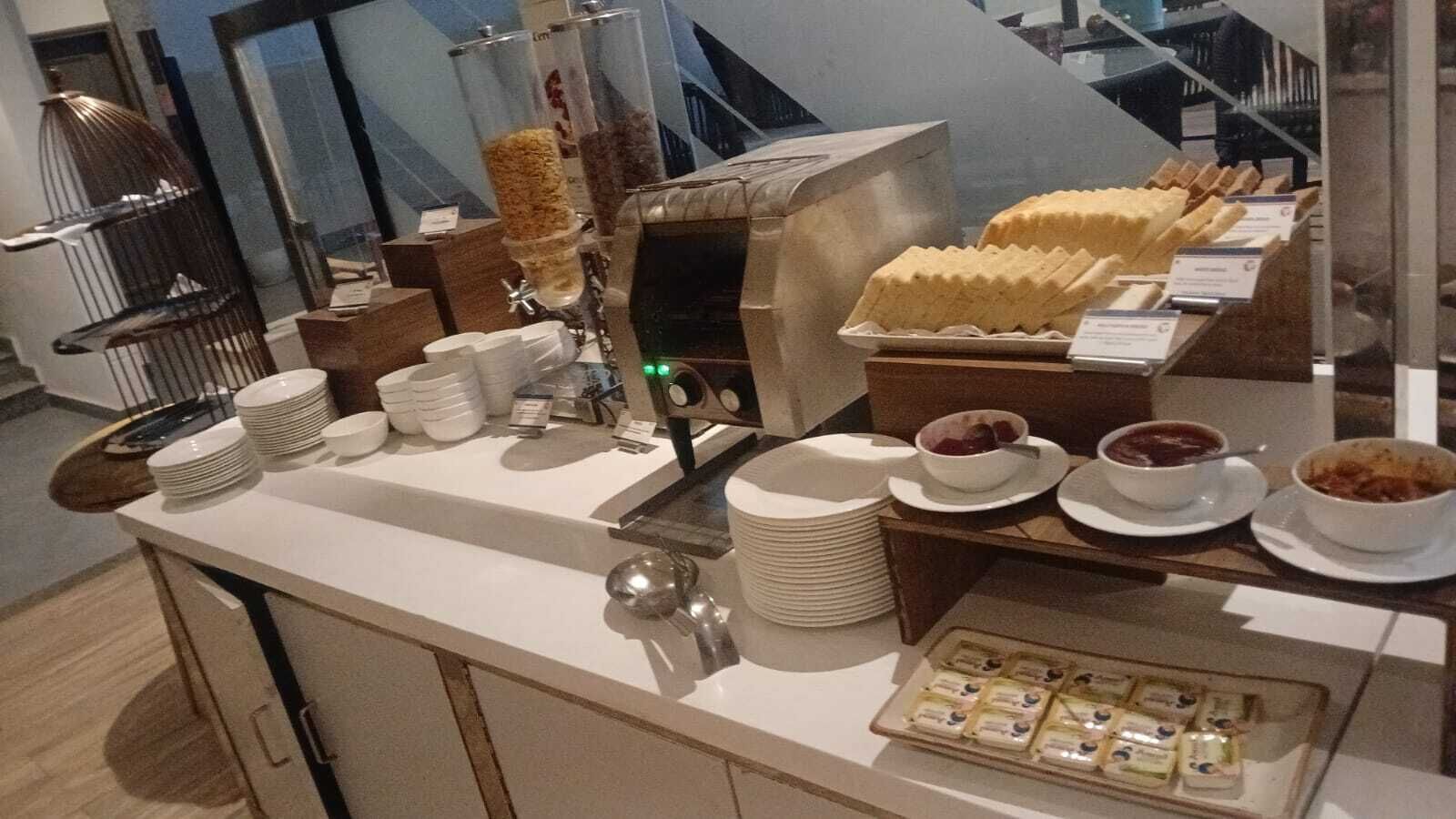 A buffet setup with various food items, plates, and serving utensils.