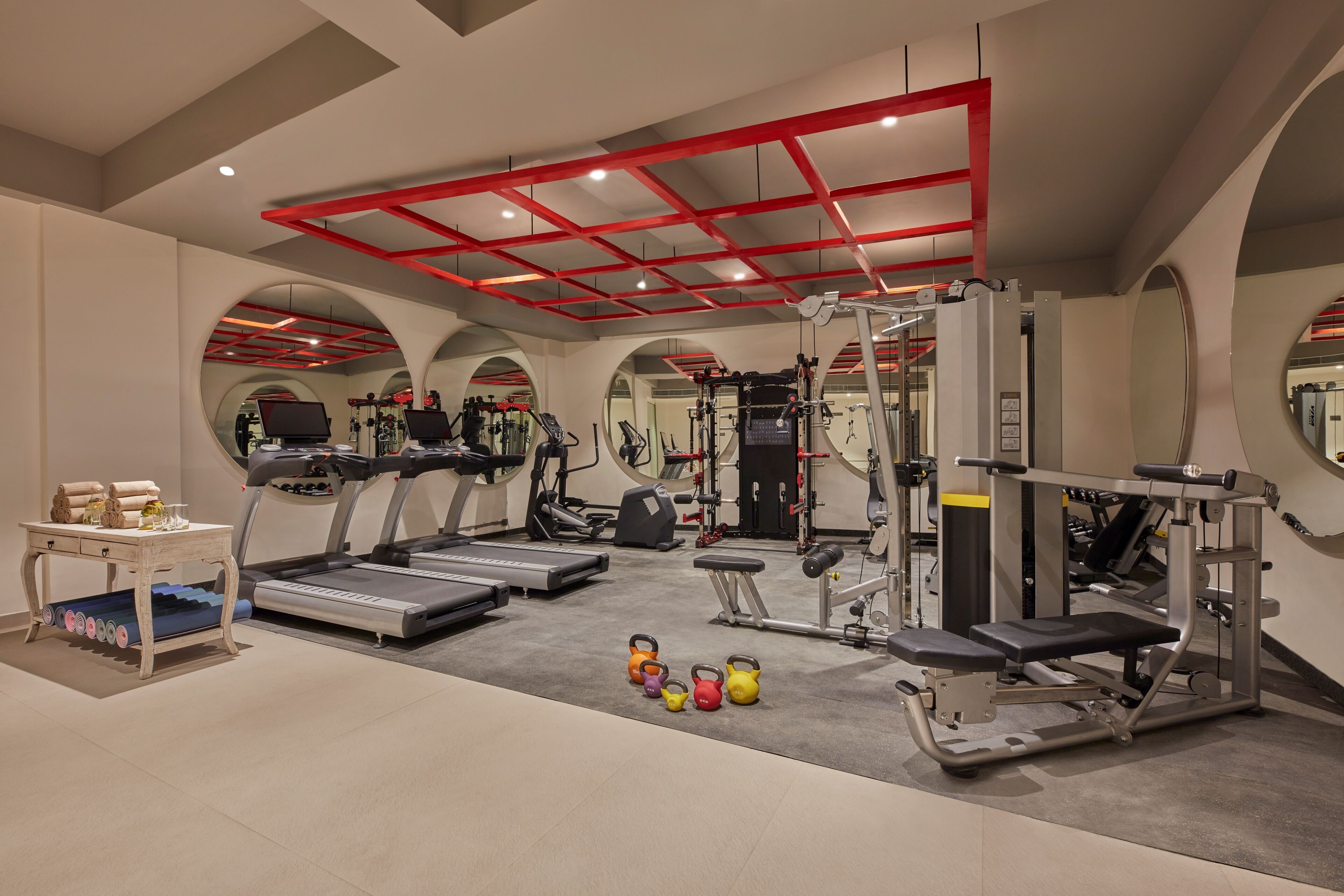 A modern gym with treadmills, weight machines, and kettlebells.