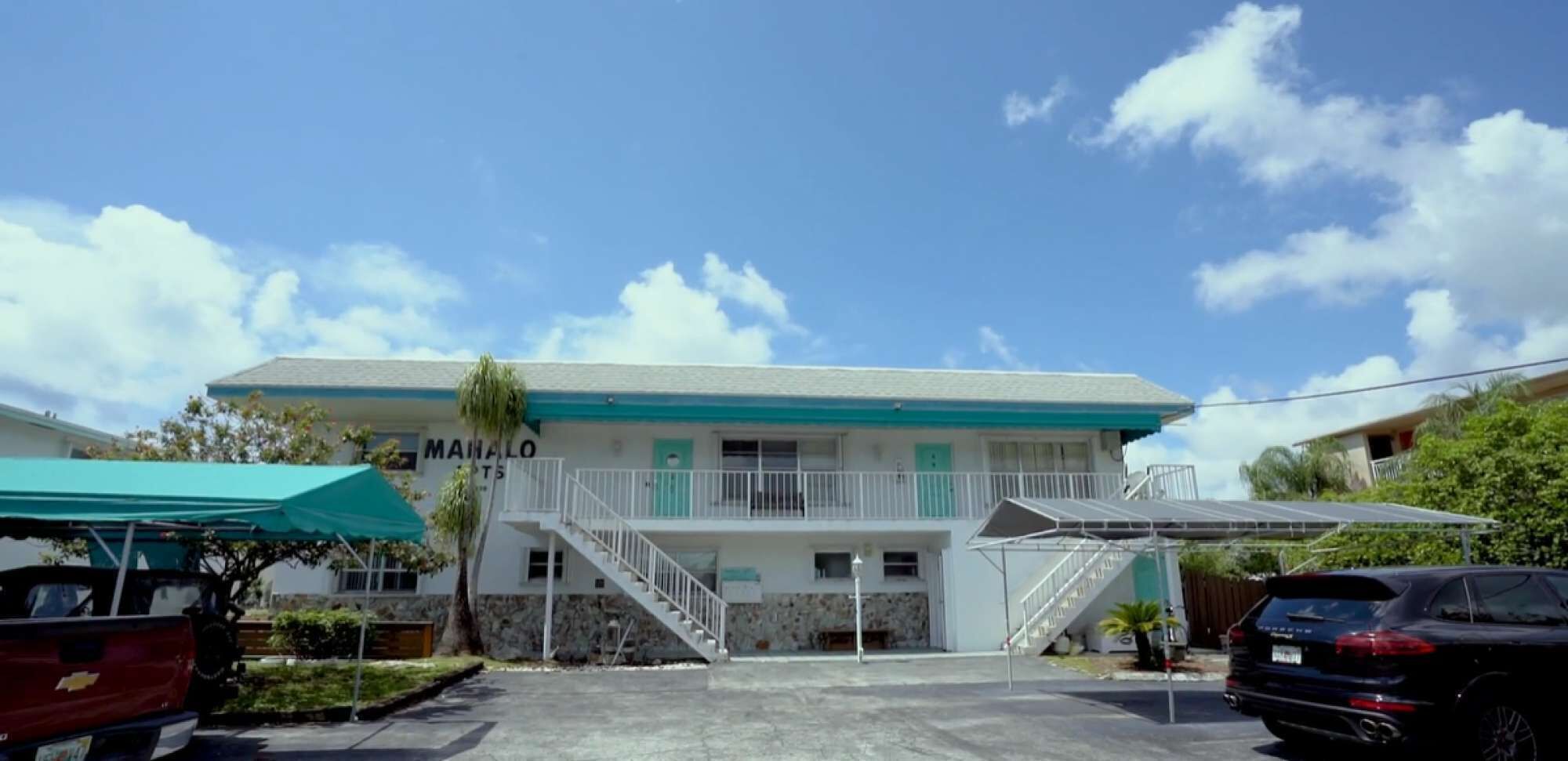 A two-story building with a sign reading "MANALO".