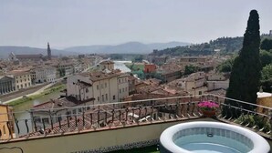 A rooftop terrace with a hot tub, a view of a cityscape, and a river in the background. - Florence Rooftop Apt - Jacuzzi & Panoramic View (Firenze)