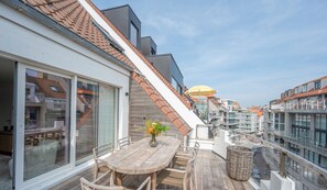 A wooden deck with a table and chairs, a wicker basket, and a sign indicating 'Floor 1 Seaside'.