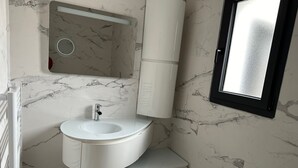 A bathroom with a white marble sink, a mirror, and a window. - Maison Magnifique Carcassonne (Carcassonne)