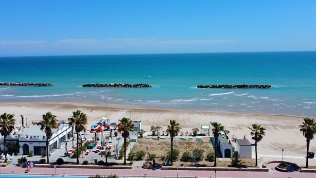A beachside hotel with a pool, palm trees, and a view of the ocean. - [50m from the Beach] Modern Studio with WiFi & A/C (Lido Di fermo)