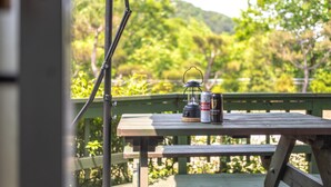 A wooden picnic table with a lantern and two cans of beer on it. - Yangpyeong Dodam Dodam Pension (Yangpyeong)