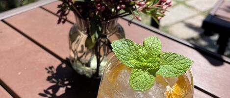 Un verre de boisson glacée, décoré d’une feuille de menthe, posé sur une table en bois.