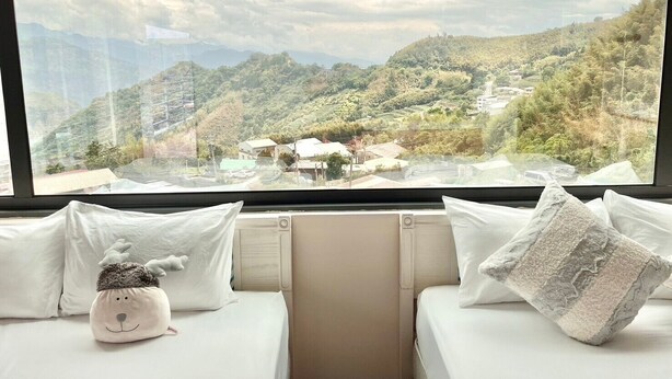 Une chambre avec un lit et une fenêtre donnant sur un paysage montagneux.