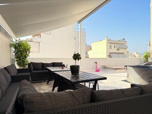 A rooftop terrace with outdoor furniture, a table, and potted plants. - P7 - 2 Bedrooms Jacuzzi Rooftop (Athens)