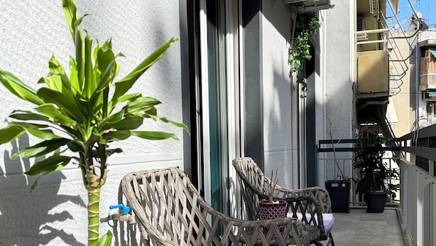 Wicker chairs with cushions on a balcony, a potted plant, and a water spigot. - P7 - 2 Bedrooms Jacuzzi Rooftop (Athens)
