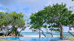 An infinity pool with a view of the ocean, surrounded by trees and a clear sky. - South Point Abbey Whole Villa 4 Bedroom (Sleeps 9) (Koggala)