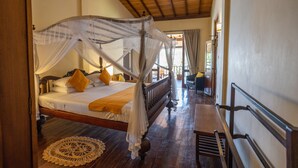 A bedroom with a four-poster bed, wooden flooring, and a ceiling fan. - South Point Abbey Whole Villa 4 Bedroom (Sleeps 9) (Koggala)