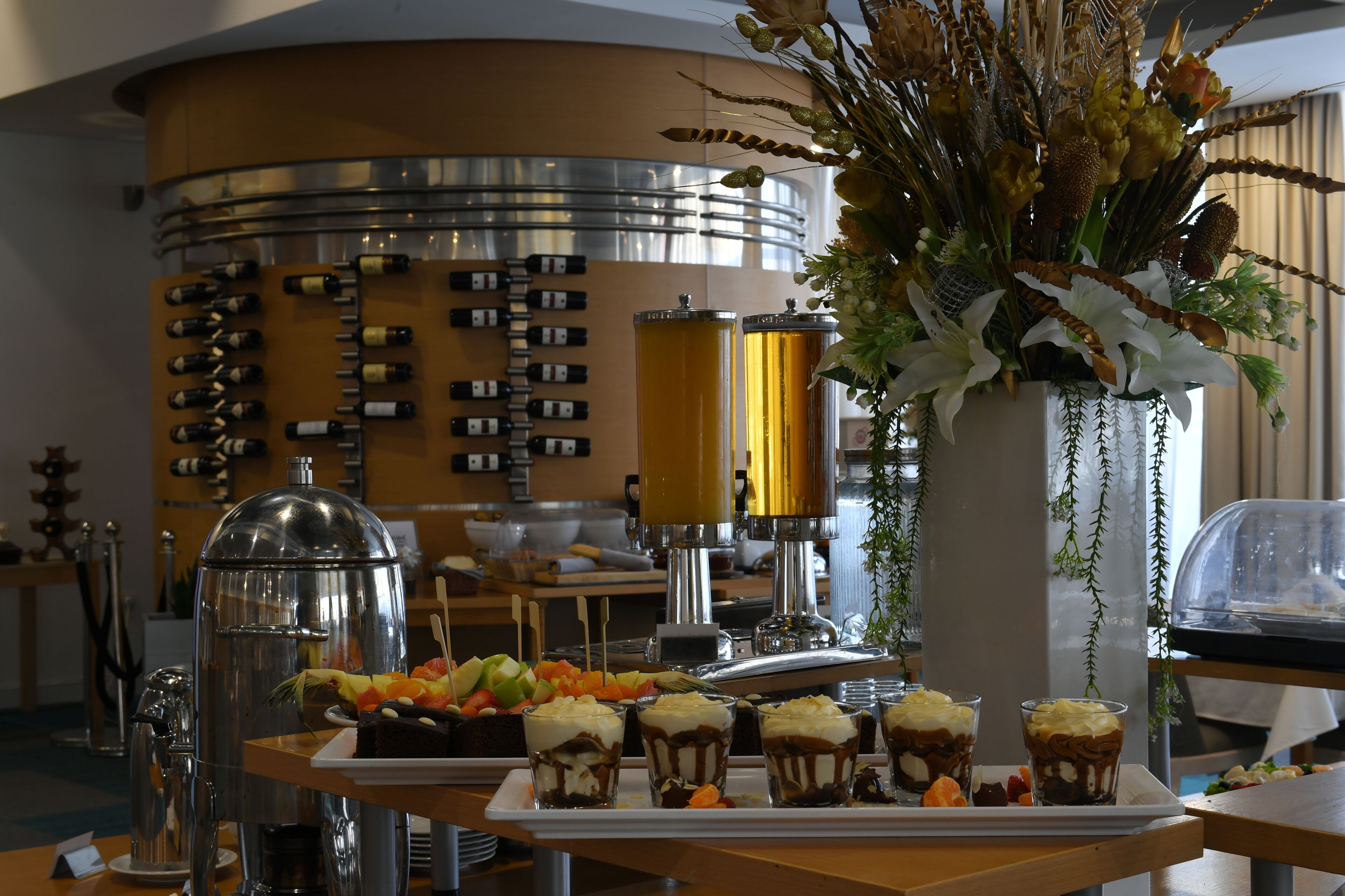A buffet setup with various food items and a wine selection.