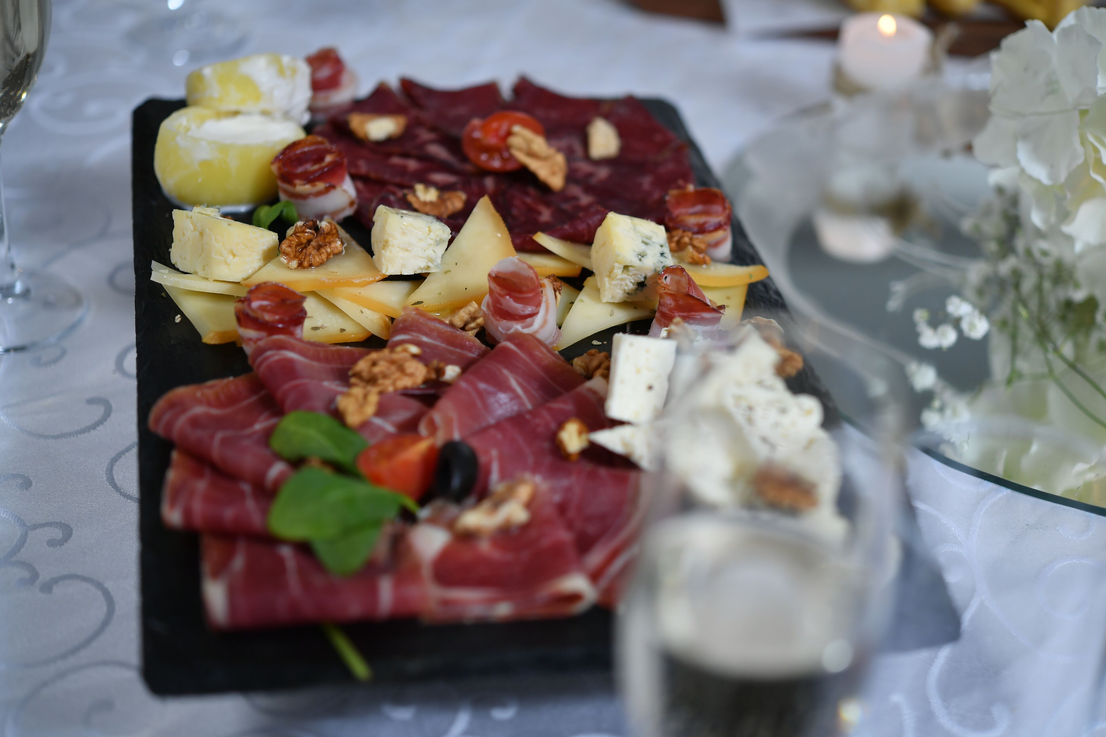 Une planche de charcuterie avec divers fromages, viandes et fruits secs.
