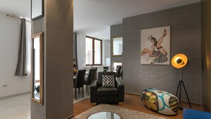 A modern living room with a sofa, a glass coffee table, and a colorful bean bag. - Apartment Frankie's Place (Dubrovnik)