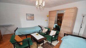 A small, furnished room with two beds, a table, chairs, and a mirror. - Holiday Home Katarina (Vinodol)