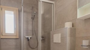 A modern bathroom with a glass-enclosed shower, a white toilet, and a sink with a mirror above it. - Studio Rénové à Grimentz (Grimentz)