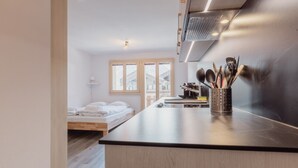 Une cuisine moderne dotée d’un plan de travail en bois, d’une cuisinière encastrée et d’un porte-ustensiles.