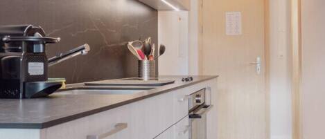 Cafetera o tetera, frigorífico, horno y placa de cocina