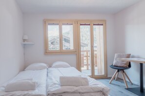Une chambre à coucher avec un lit, un bureau et une chaise.