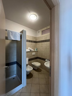 A bathroom with a shower, toilet, bidet, and sink. - One Bedroom Apartment   Sea Side (Marzamemi)