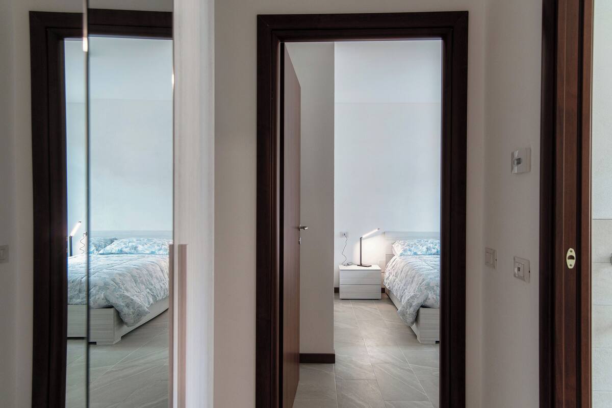 A hotel room with a bed, bedside table, and a nightstand.