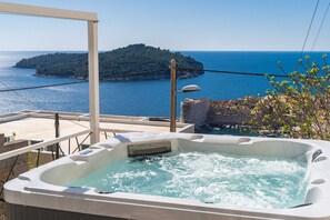 A hot tub with a view of the sea and a small island. - Duxperience Apartment (Dubrovnik)