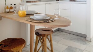 Una cocina moderna con armarios blancos, una mesa de comedor de madera y un microondas integrado.