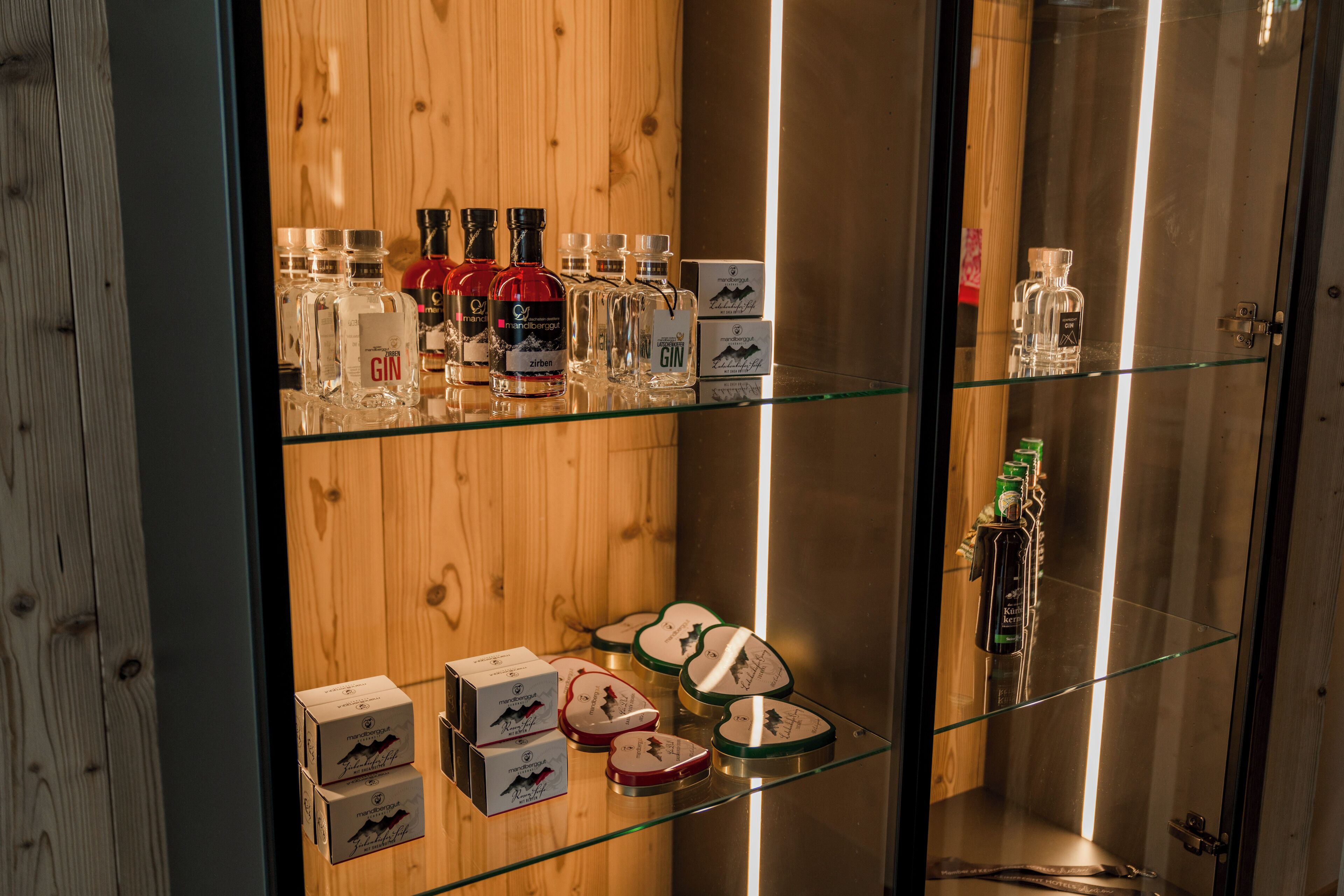 Une vitrine en verre contenant diverses bouteilles et boîtes, qui renferment probablement des spiritueux ou des liqueurs.
