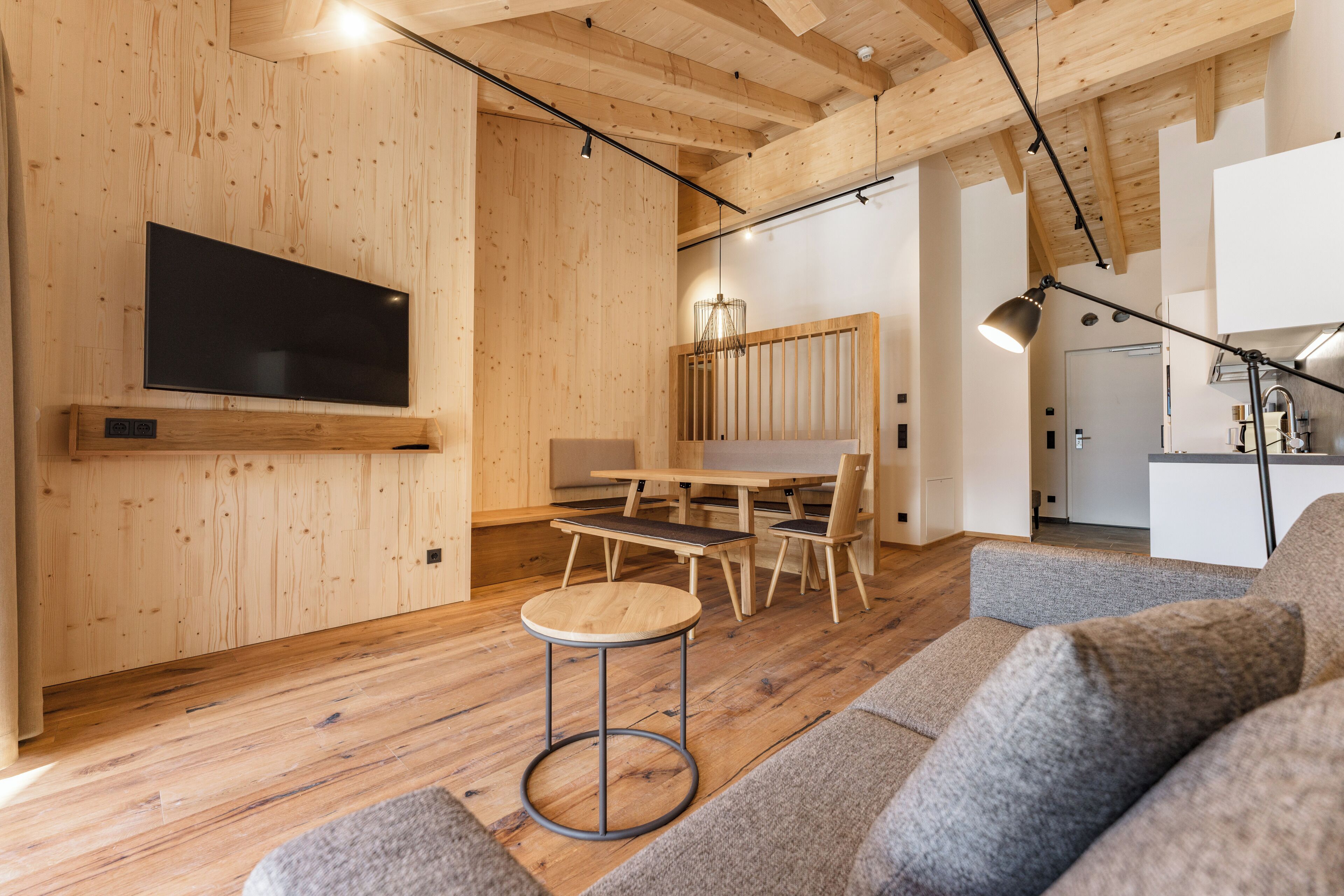 Un interior modern amb parets de fusta, una televisió de pantalla plana, zona de menjador i un ambient agradable per seure.
