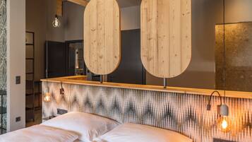 Ein modernes Schlafzimmer mit Holz-Kopfteil, einem großen Spiegel und Pendelleuchten.