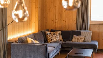 A modern living room with a grey sectional sofa, a floor lamp, and a window with curtains.