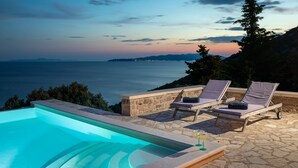 A swimming pool with lounge chairs and a sunset view. - Stone Houses Dingač (Orebic)