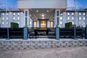 A hotel entrance with a sign reading "spark by Hilton" and a stone wall in front. - Spark by Hilton Branson Meadows (Branson)
