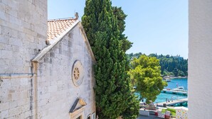 A historic building with a clock, a staircase, and a view of a marina with boats. - Apartments Villa Royale (Konavle)