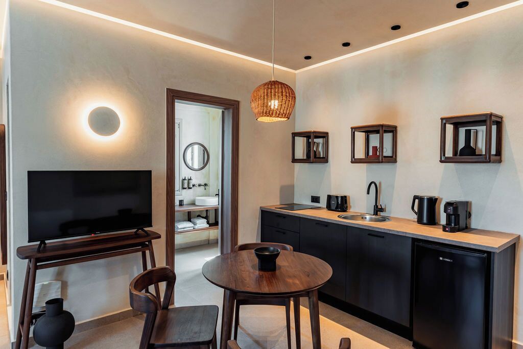 A modern kitchen with a TV, dining area, and built-in appliances.