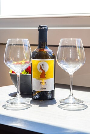 A bottle of Greco Campaniaig wine and two glasses on a table. - Chiave di Fuga - Tripla Superior (Naples)