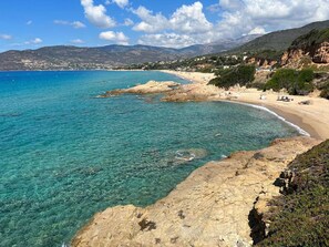 A coastal landscape with clear turquoise waters, rocky shores, and a sandy beach. - Quiet 2-Room Apartment with Terrace - Cargese Center (Cargèse)