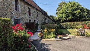 A stone building with a sloped roof and a small porch. - Charming house in Vessey with TV and internet (Pontorson)