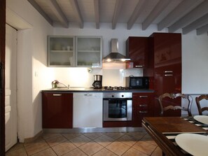 A compact kitchen with a dishwasher, stove, oven, and microwave.