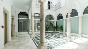 Un vaste atrium doté d’un sol à carreaux, de colonnes en marbre et d’un balcon donnant sur les environs.