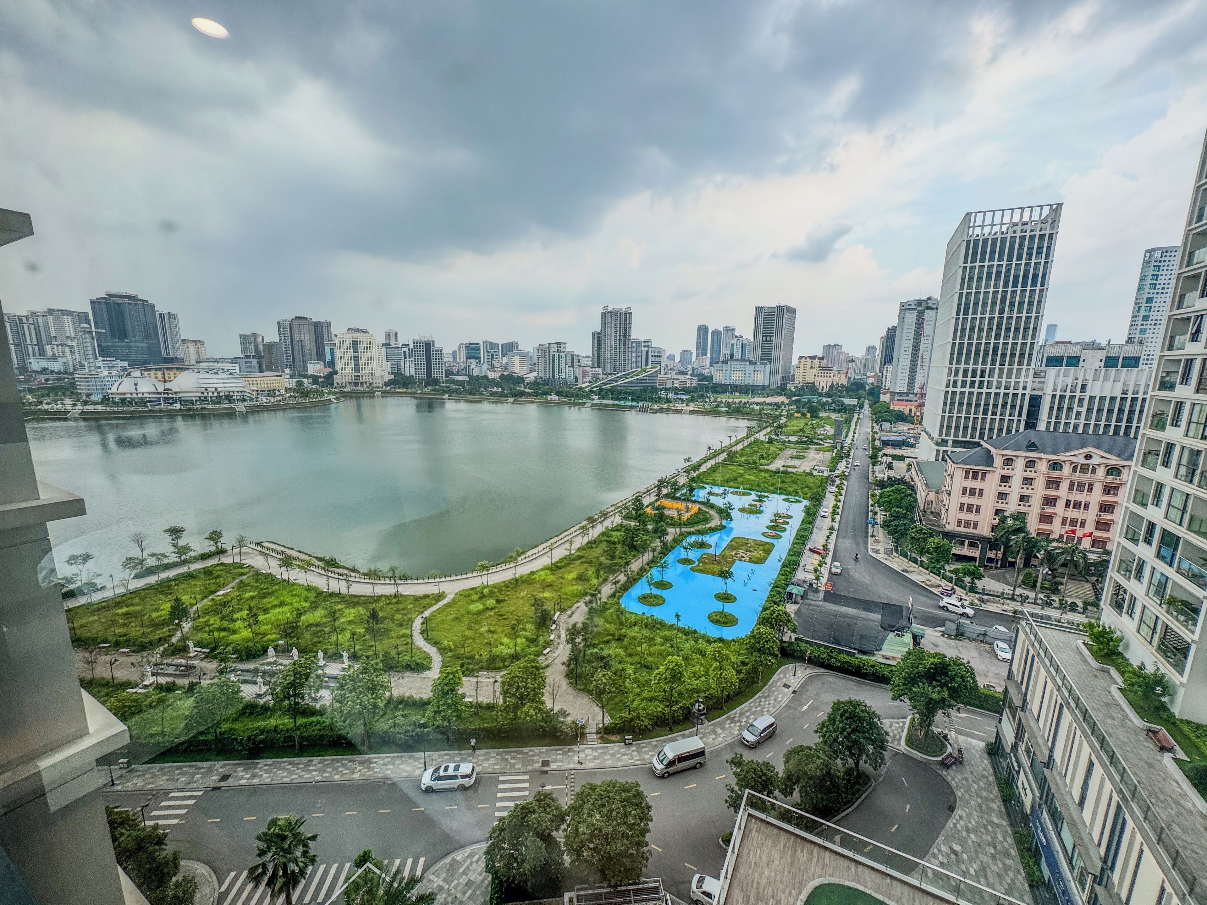 A cityscape with a large body of water, green spaces, and modern buildings.