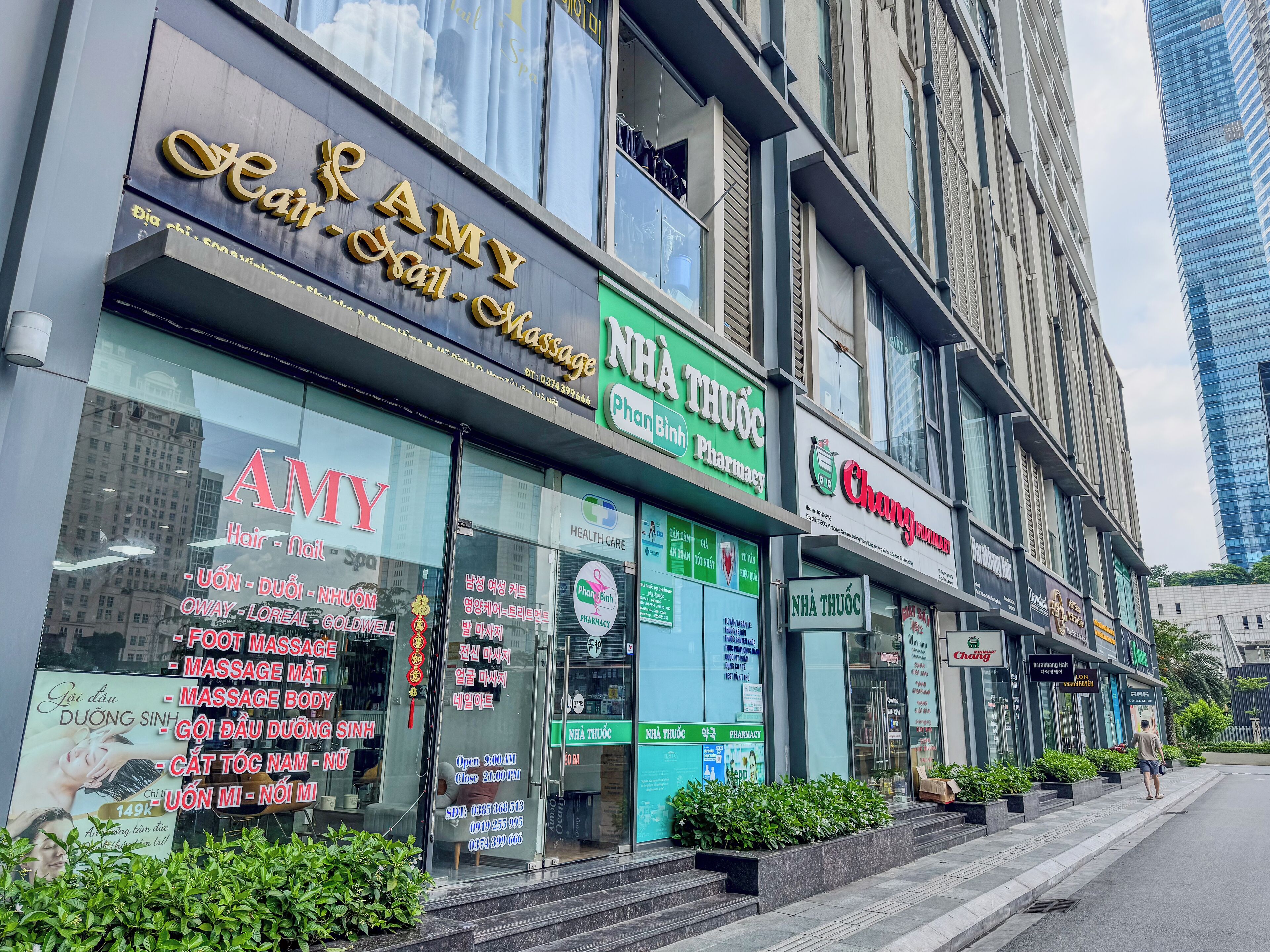 Un immeuble abritant plusieurs commerces, notamment un salon de coiffure, une pharmacie et un centre de soins de santé.