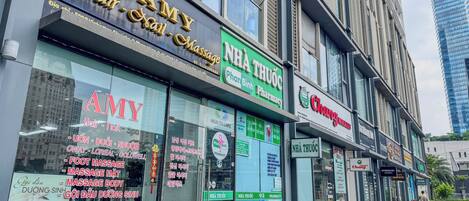 Un immeuble abritant plusieurs commerces, notamment un salon de coiffure, une pharmacie et un centre de soins de santé.