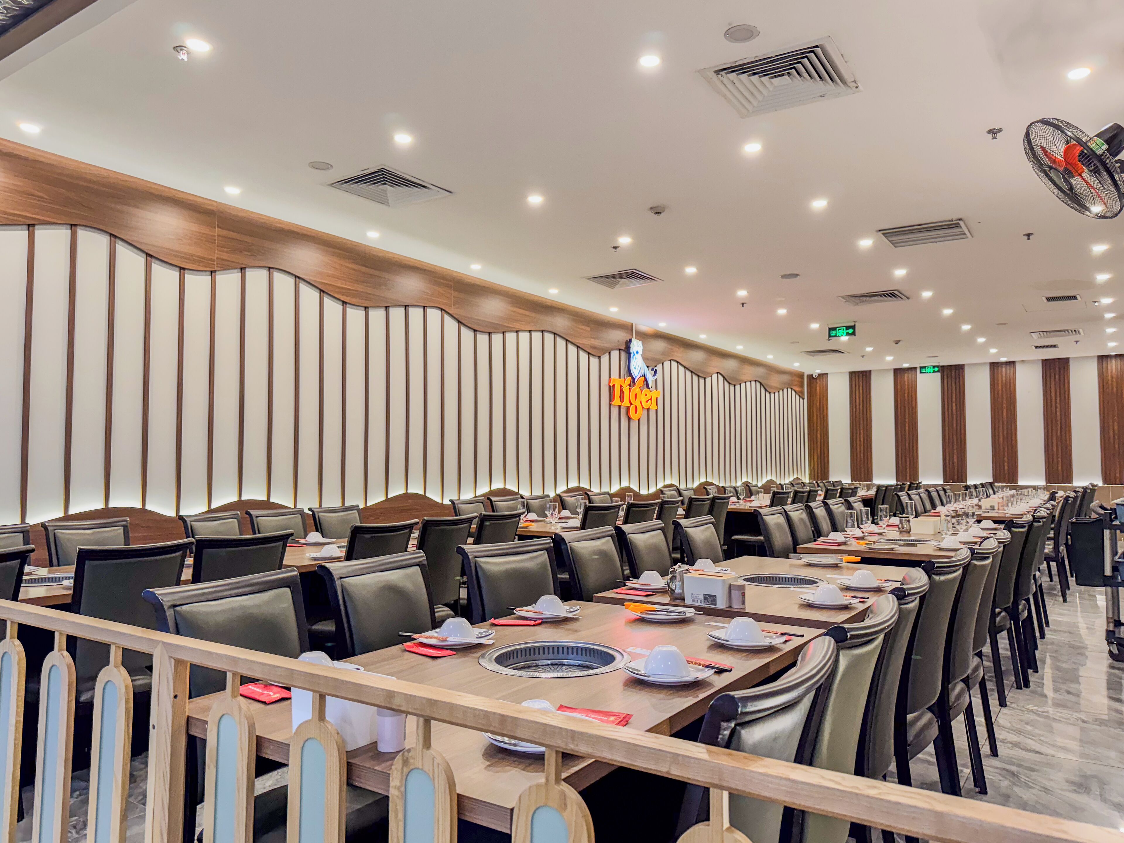 A conference room with long tables, chairs, and a modern ceiling design.