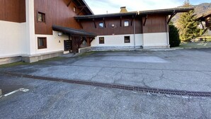 A large building with a wooden exterior, multiple windows, and a covered entrance area.
